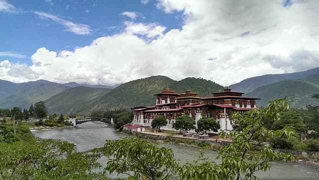 A whitewashed Bhutanese dzong fortress-monastery above a river valley