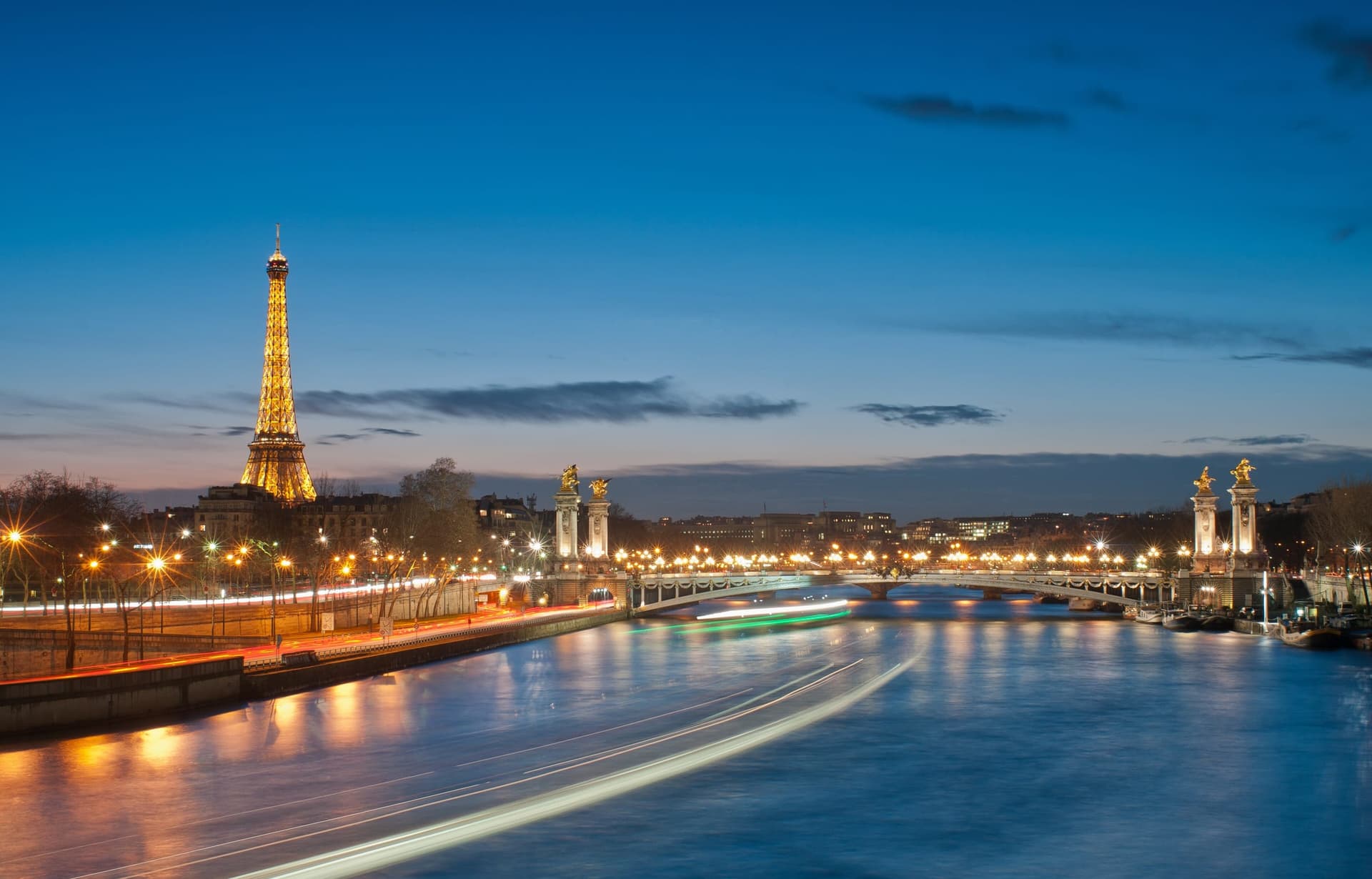 The Eiffel Tower rising above the rooftops of Paris at dusk
